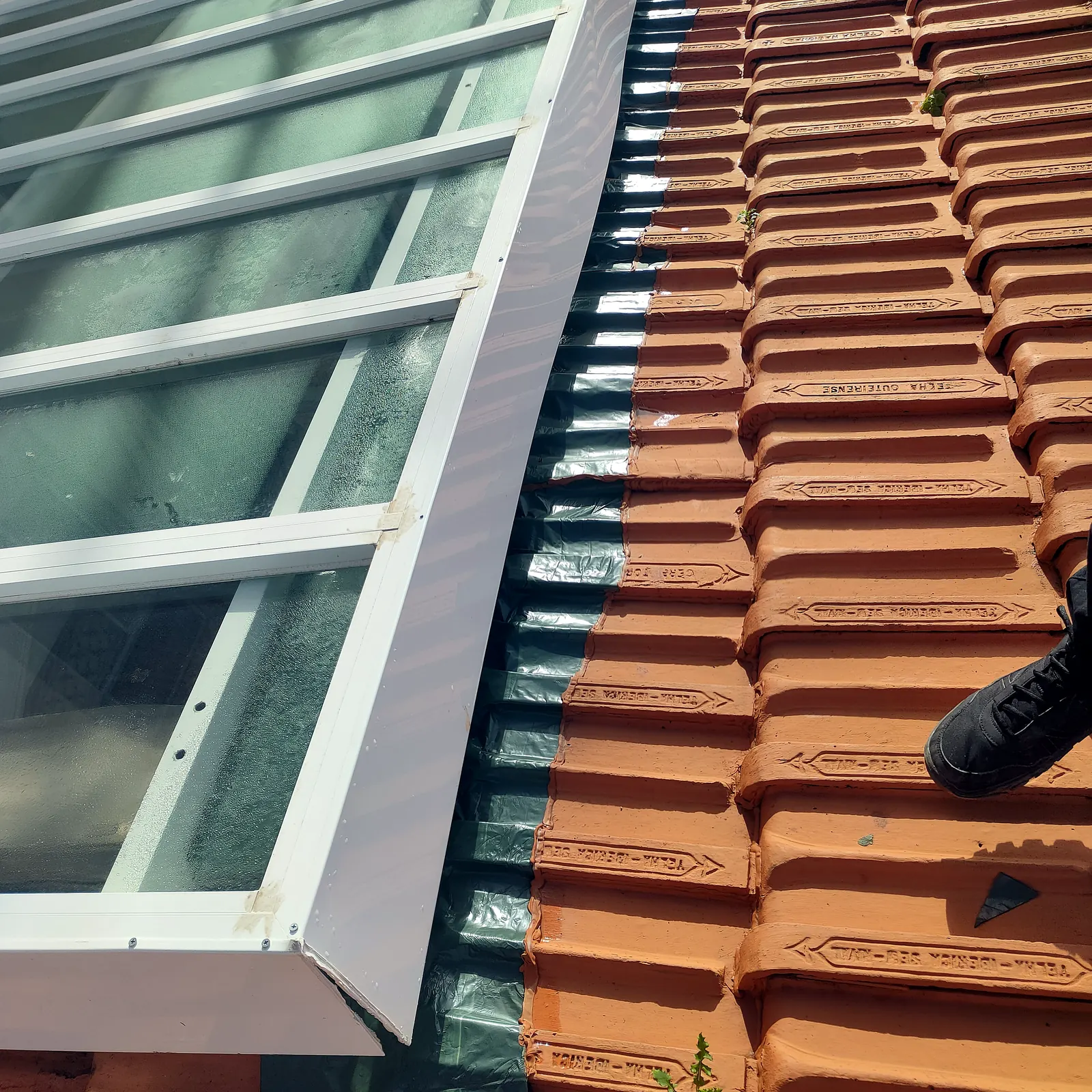 Claraboia renovada com rufos novos sobre telhado de telha cerâmica
