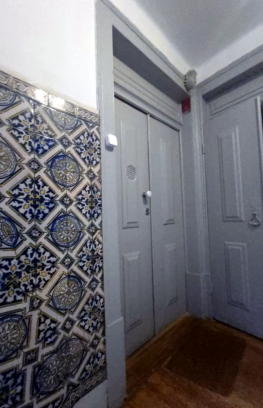 Entrada de habitação reabilitada com azulejo tradicional e portas restauradas